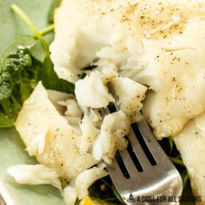 smoked cod being flaked with a fork