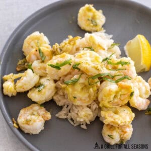 blackstone shrimp with basil and lemon close up served on a bed of rice