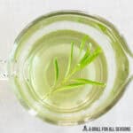 rosemary simple syrup recipe in small glass pitcher