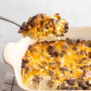 ground beef hashbrown casserole recipe being served from baking dish with spoon