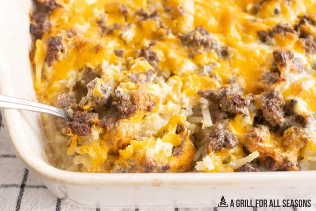 ground beef hashbrown casserole recipe in baking dish with spoon