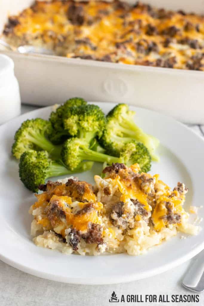 ground beef hashbrown casserole on dinner plate with baking dish behind