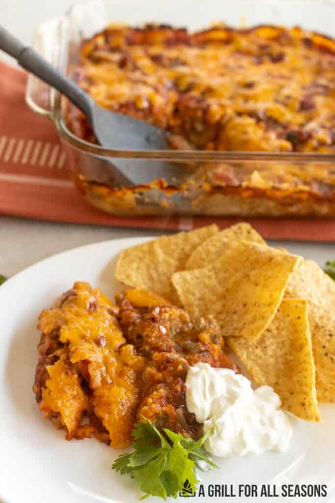 venison casserole recipe on plate with tortilla chips with baking dish behind
