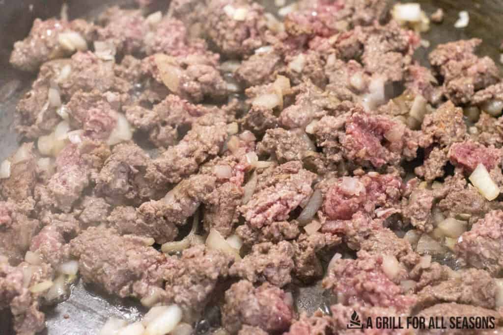 ground meat and onions in skillet