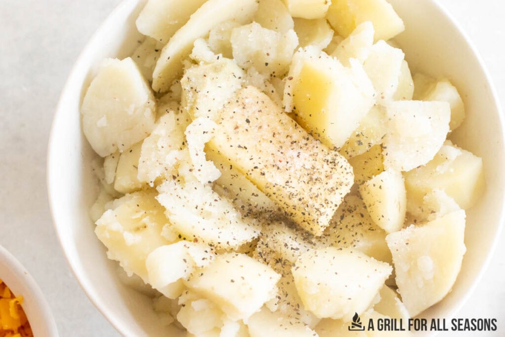potatoes in bowl with butter and seasoning