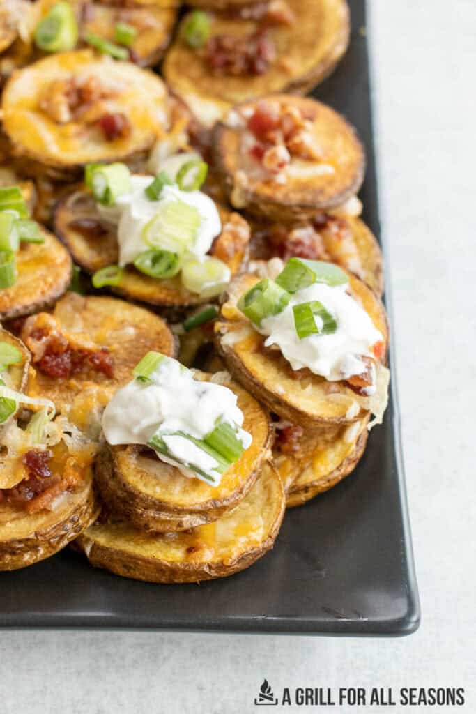 loaded potato bites topped with sour cream and slices of green onions