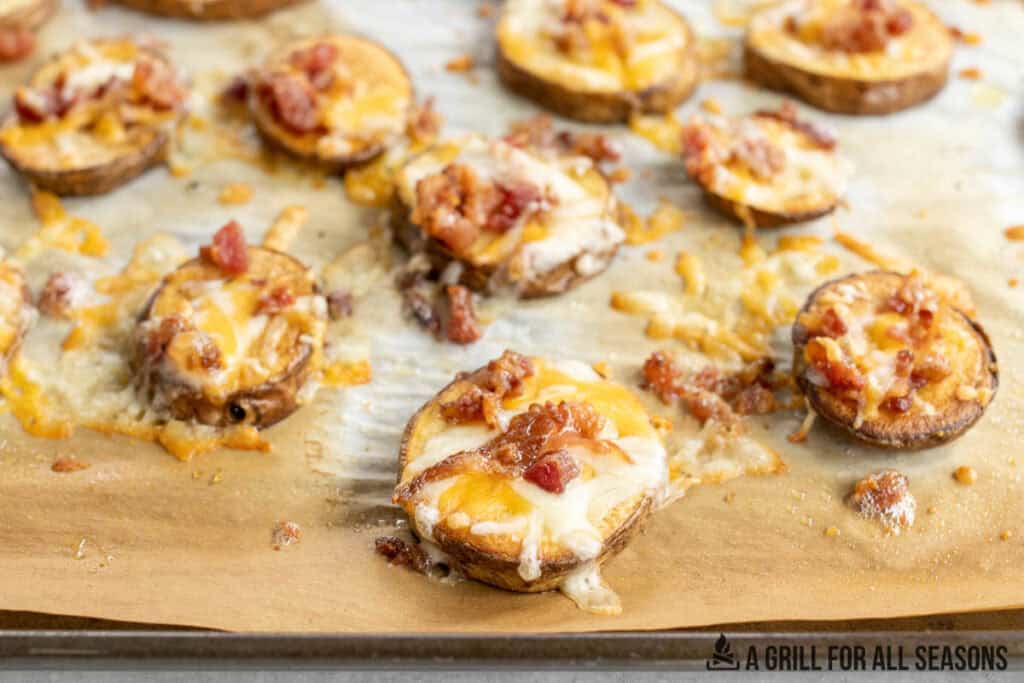 loaded potato bites topped with cheese and bacon on baking pan