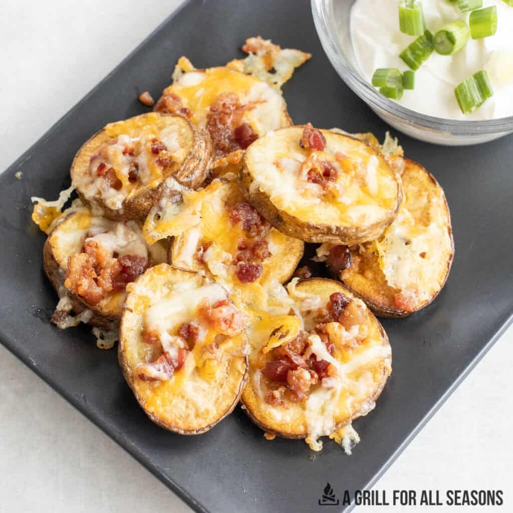 loaded potato bites with toppings on a serving plate