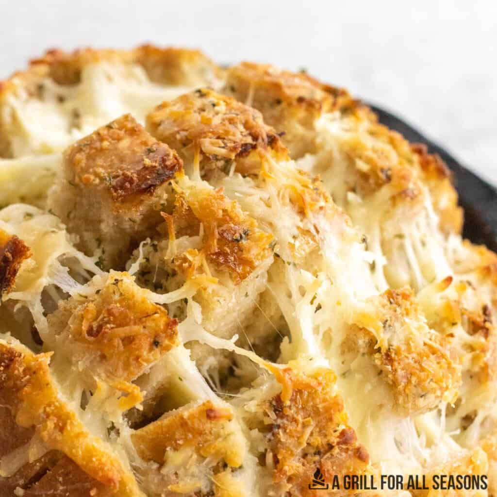 cheese stuffed garlic bread being lifted to show melty cheese