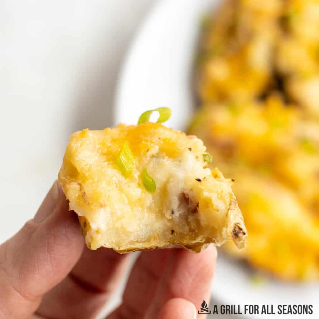 hand holding up a potato with bite missing