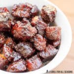 candied pork belly recipe close up in a bowl with wood background