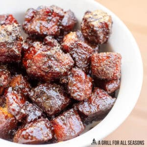 candied pork belly recipe close up in a bowl with wood background