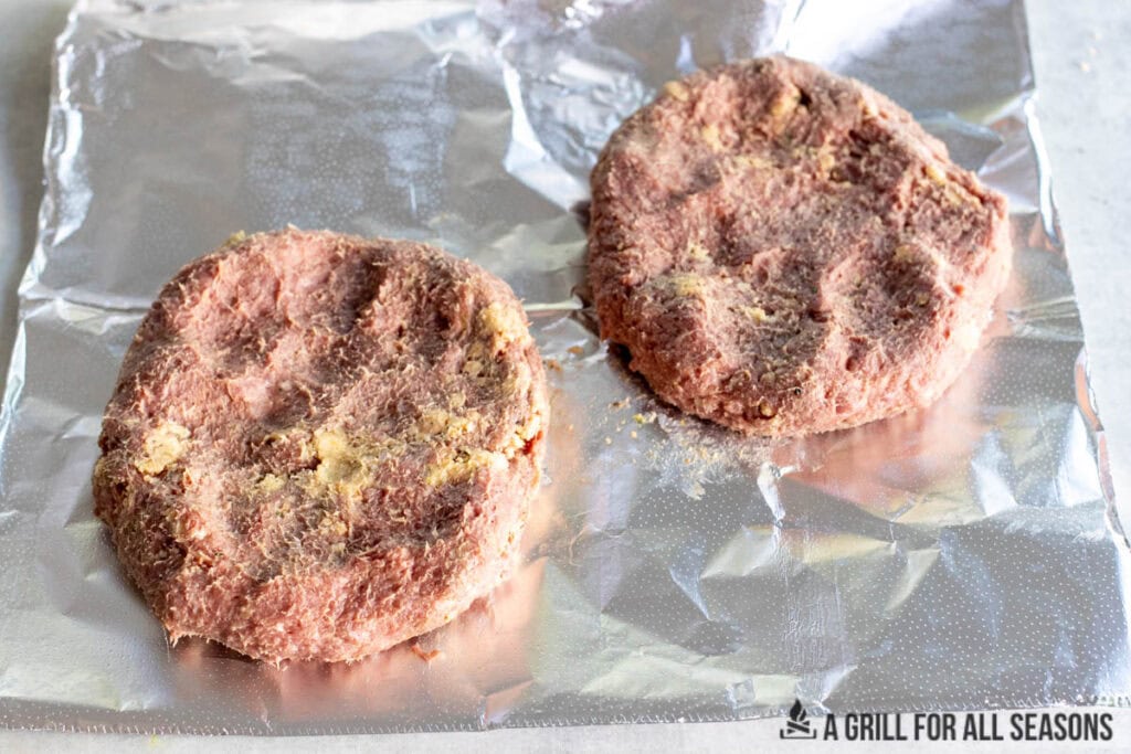 raw beef shaped into patties on foil