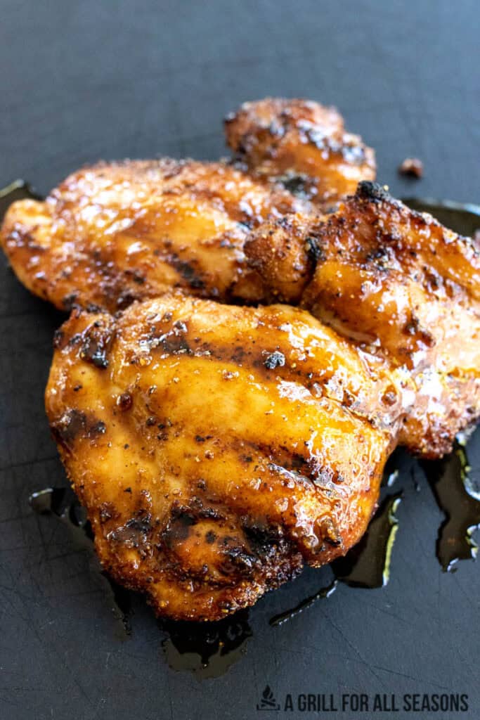 hot honey grilled chicken resting on cutting board