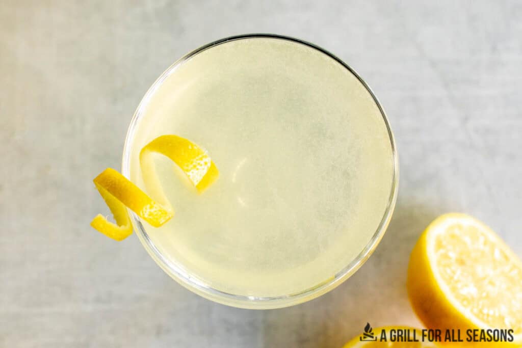 overhead shot of lemon martini and cut lemons on the side