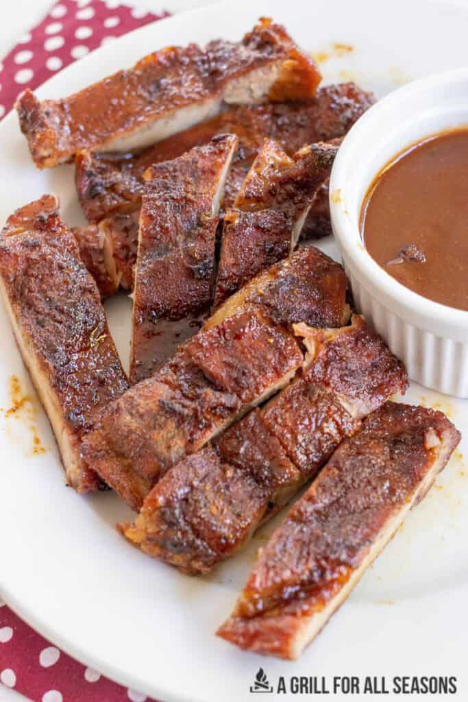pork belly steak bites on plate with ramekin of bbq sauce
