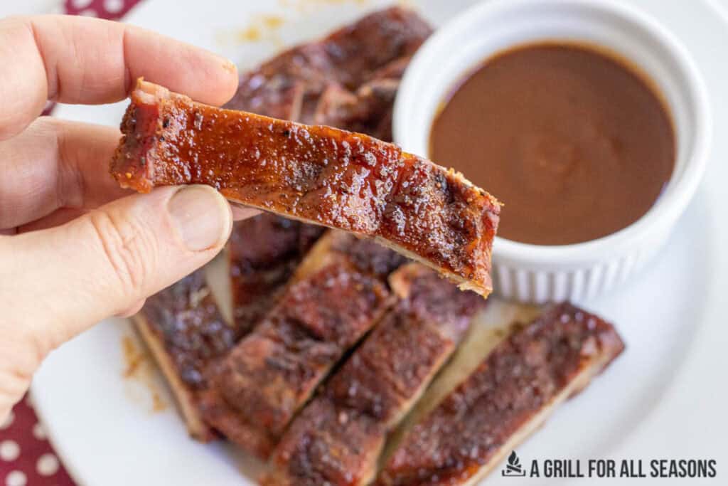 hand holding a strip of pork belly steak