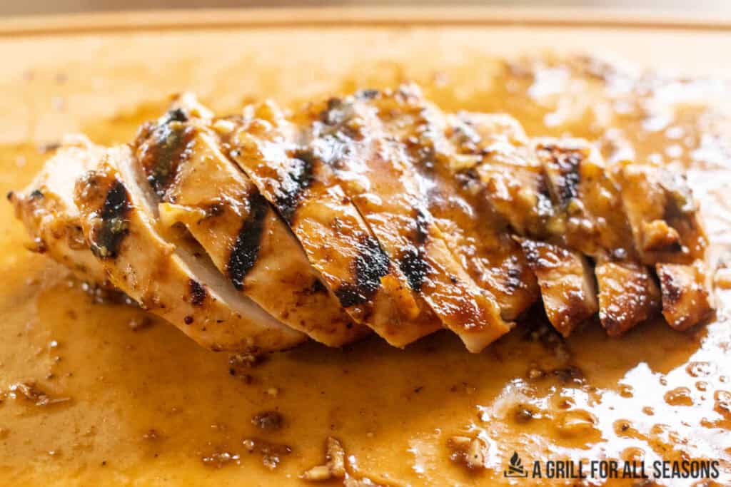 grilled chicken with honey mustard marinade sliced on cutting board from side