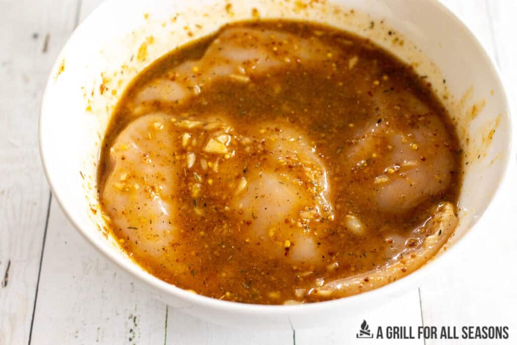 chicken in bowl with marinade close up