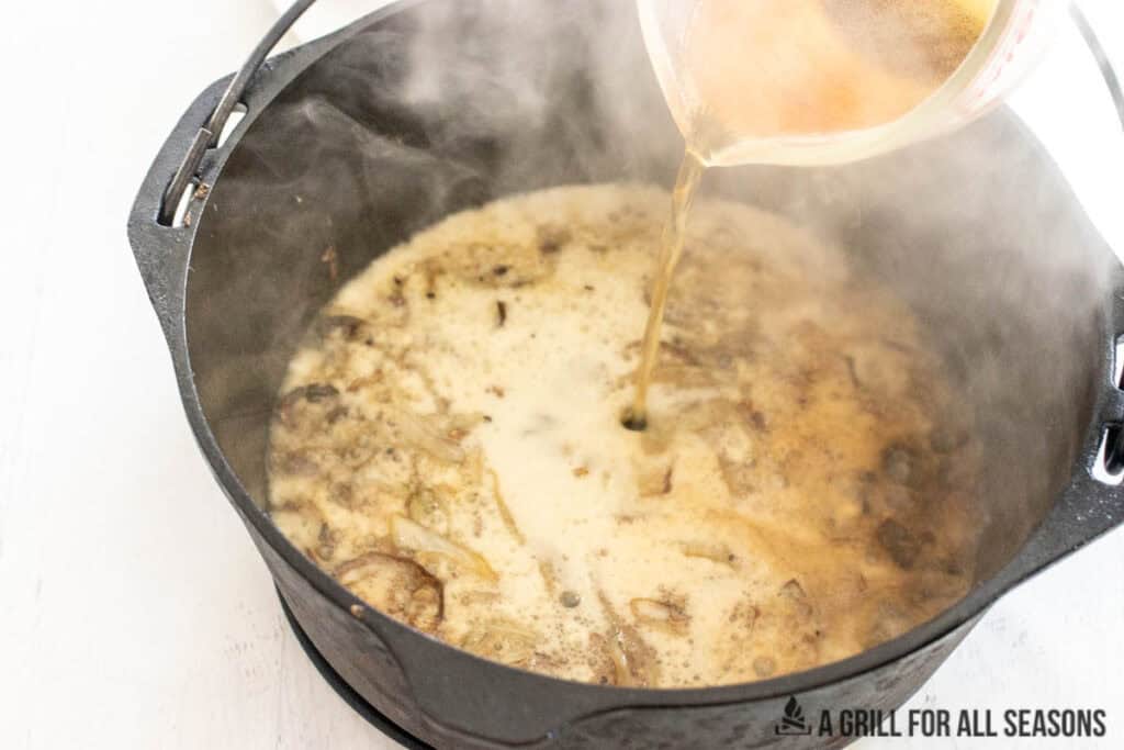 beer being added to the dutch oven