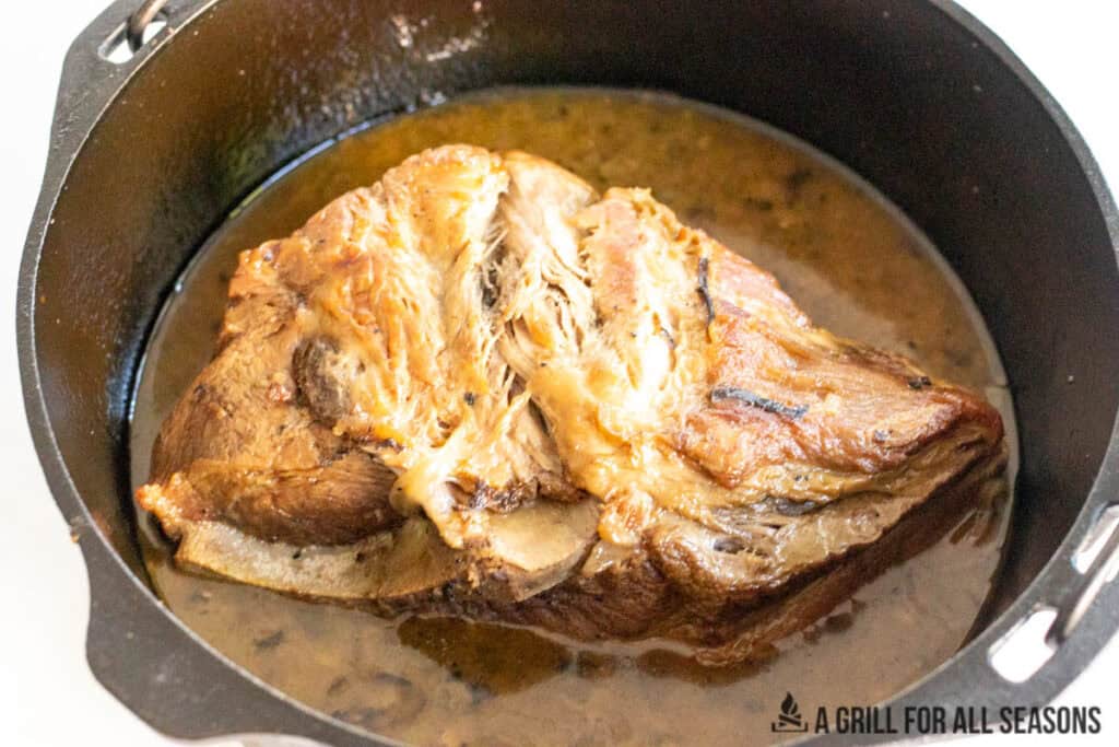 meat in braising liquid in dutch oven
