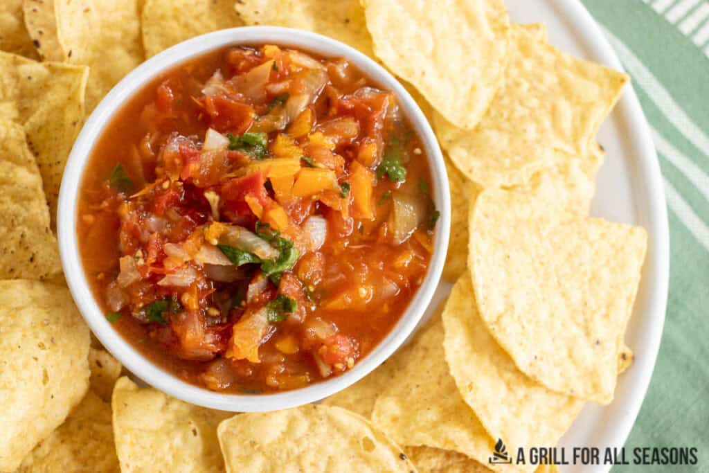 overhead shot of bowl of smoked salsa in the middle of a platter of tortilla chips