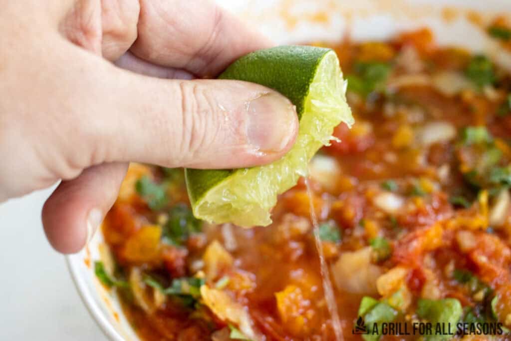 hand squeezing lime juice into bowl