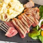 pellet grill steak on plate with a bite on a fork and sides